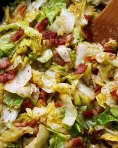 Plate of Southern fried cabbage garnished with bacon and onions